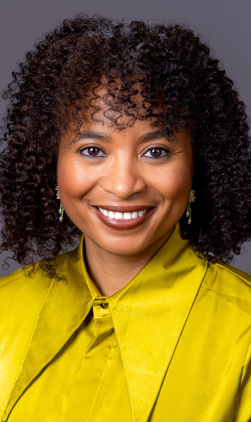 Black woman with green shirt and curly hair